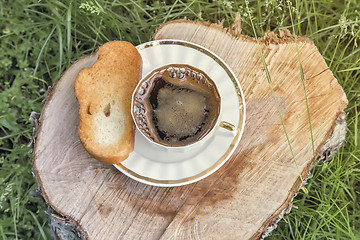 Image showing Still life: a Cup of black coffee in the garden.