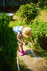 Image showing Little happy girl watering garden