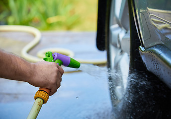 Image showing People cleaning car using high pressure water