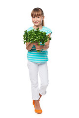 Image showing Smiling elementary school age girl showing fresh parsley