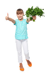 Image showing Smilinglittle girl showing fresh parsley and gesturing thumb up