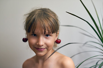 Image showing Little girl with a cherry on her ears