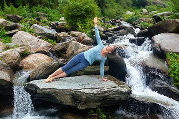 Image showing Woman doing yoga asana Vasisthasana - side plank pose outdoors