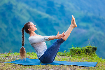 Image showing Woman doing Ashtanga Vinyasa Yoga asana Navasana - boat pose