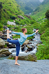 Image showing Woman doing yoga asana Natarajasana outdoors at waterfall