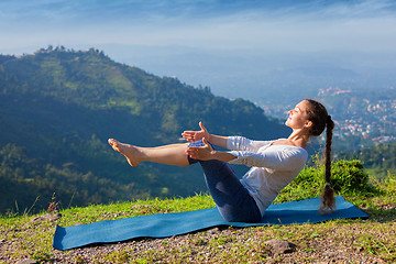 Image showing Woman doing Ashtanga Vinyasa Yoga asana Navasana - boat pose