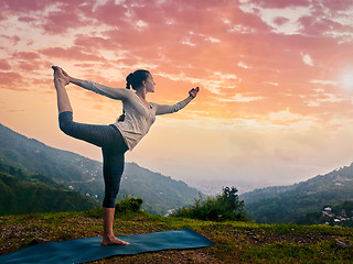 Image showing Woman doing yoga asana Natarajasana outdoors at waterfall