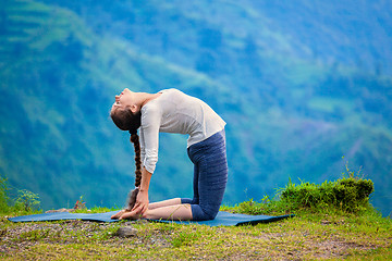 Image showing Woman doing yoga asana Ustrasana camel pose outdoors