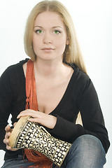 Image showing green-eyed pretty blonde with djembe