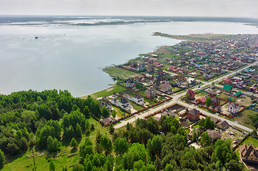 Image showing Beautiful small green village near lake and forest