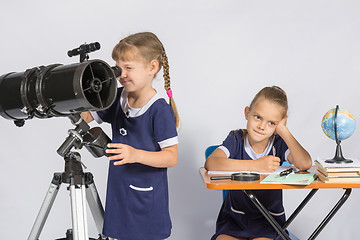 Image showing Girl astronomer looks through the eyepiece of the telescope, the other girl thinking waiting for the results of observations