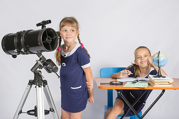 Image showing Girl astronomer looks at the sky, the other girl sitting happily at the table