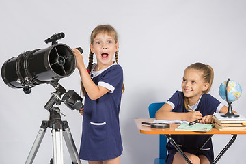 Image showing Girl surprised astronomer observing through a telescope, the other girl looked at her