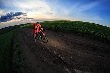 Image showing Mountain bikeer rides on the trail against beautiful sunset