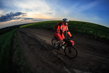 Image showing Mountain bikeer rides on the trail against beautiful sunset