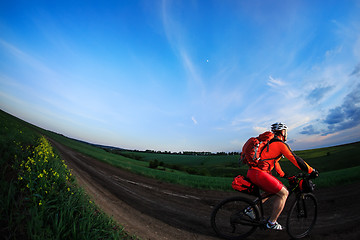 Image showing Mountain bikeer rides on the trail against beautiful sunset