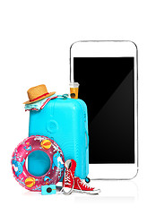 Image showing The blue suitcase, sneakers, clothing, hat, and phone on white background.