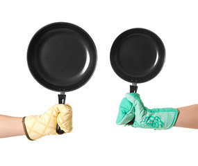 Image showing two hands in gloves holding pan\'s