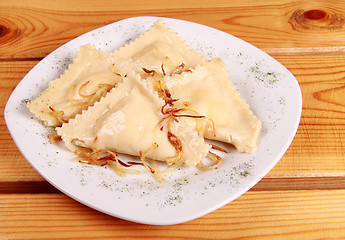 Image showing Cooked raviolli with mushrooms on a shiny white plate