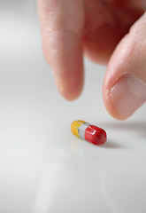 Image showing hand picking up a pill