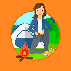 Image showing Woman kindling campfire.