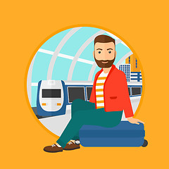 Image showing Man sitting on suitcase at the train station.