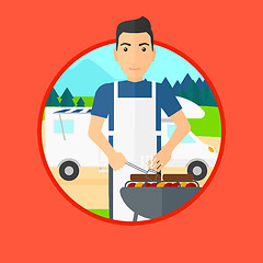 Image showing Man having barbecue in front of camper van.