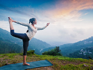 Image showing Woman doing yoga asana Natarajasana outdoors at waterfall