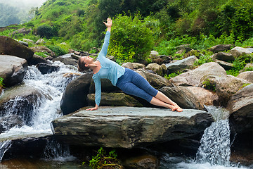 Image showing Woman doing yoga asana Vasisthasana - side plank pose outdoors