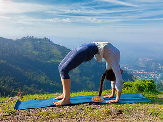 Image showing Woman doing Ashtanga Vinyasa Yoga asana Urdhva Dhanurasana outdoors