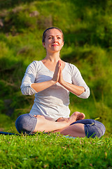 Image showing Young sporty fit woman doing yoga Lotus pose oudoors 