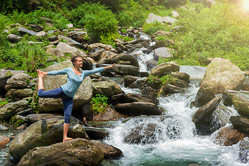 Image showing Woman doing yoga asana Natarajasana outdoors at waterfall