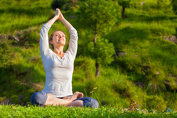 Image showing Young sporty fit woman doing yoga Lotus pose oudoors 