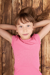 Image showing Top view of a little girl lying on back