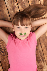 Image showing Top view of a little girl lying on back