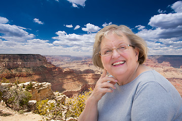 Image showing Happy Senior Woman Posing on Edge of The Grand Canyon