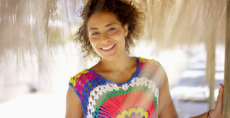 Image showing Woman under thatch beach umbrella