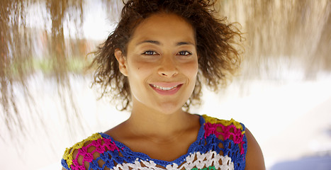 Image showing Woman under thatch beach umbrella