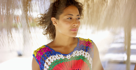 Image showing Serious woman under thatch beach umbrella