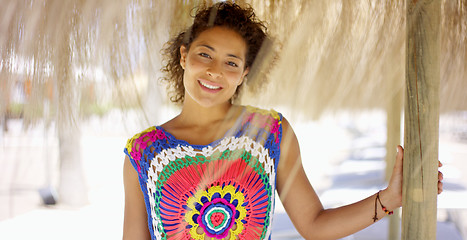 Image showing Woman under thatch beach umbrella