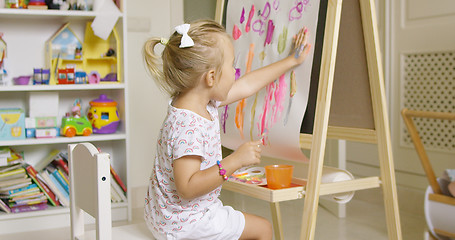 Image showing Little girl painting with her hand