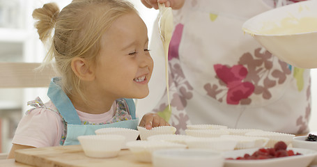 Image showing Happy little girl with empty muffin holders