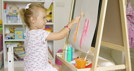 Image showing Cute little blond girl painting with watercolors