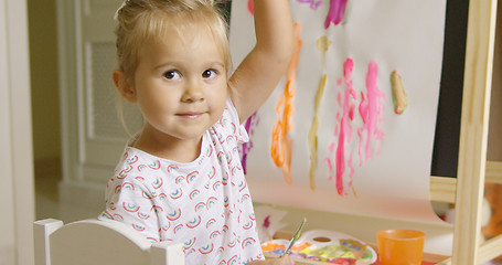 Image showing Pretty confident little girl painting at home