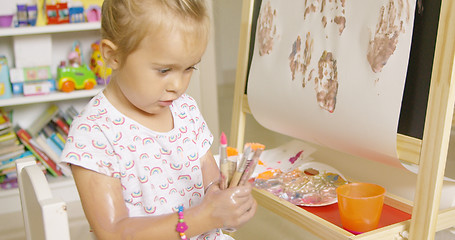 Image showing Cute little girl choosing a paint brush