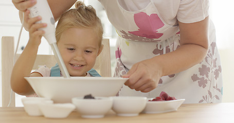 Image showing Cute happy little girl helping with the baking