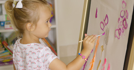 Image showing Creative little girl painting in a playroom