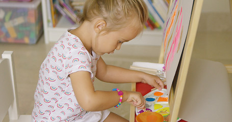 Image showing Cute little girl mixing paints for her painting