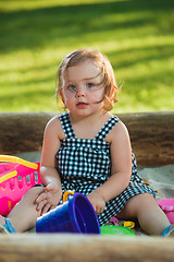 Image showing The little baby girl playing toys in sand