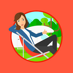 Image showing Woman sitting in chair in front of camper van.